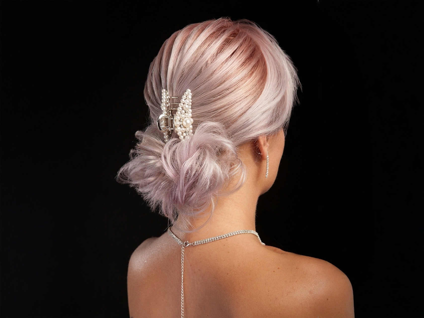 Image placeholder: a claw clip messy bun with loose texture, soft face-framing pieces, and a relaxed low shape.