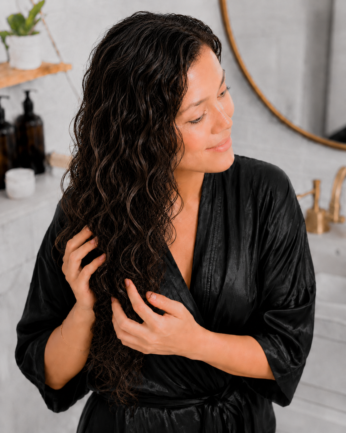 Hands gently scrunching dry wavy hair to release the cast, soft, defined waves underneath